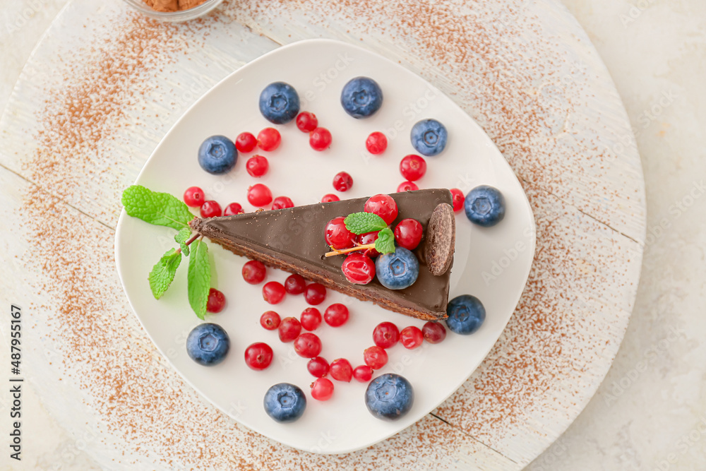 Plate with delicious piece of chocolate cake and berries on light ...