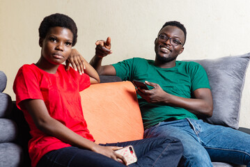 Poster - young happy couple each holding mobile phone at home.