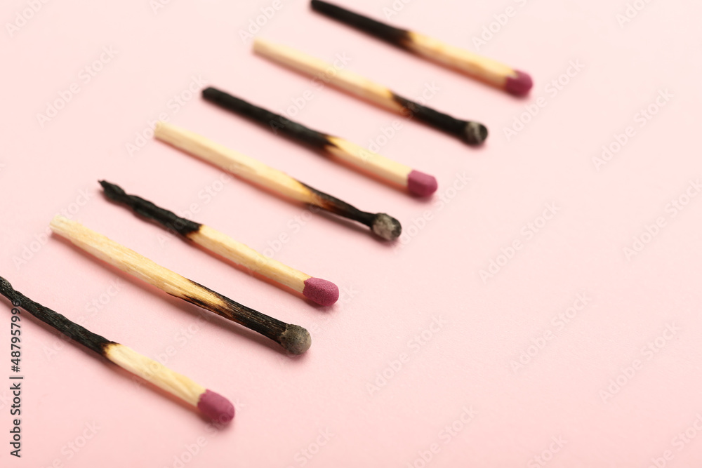 Many burnt matches on color background, closeup. Concept of work burnout