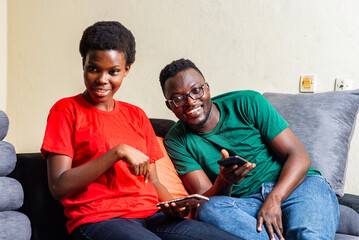 Wall Mural - young happy couple each using mobile phone at home.