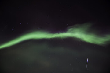Wall Mural - Northern light (Aurora Borealis) during night with Iridium flare in Oulu, Finland, Europe