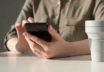 Aufkleber - Woman hands closeup holding phone. Woman sitting at table and using gadget for communication, work, education or relax. High quality photo