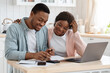 © Prostock-studio - Portrait Of Happy Black Spouses Reading Insurance Documents At Home