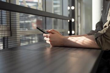 Aufkleber - Hands closeup holding phone. Woman sitting at cafe table and using smartphone for communication, work, online shopping, relax. City lifestyle concept. High quality photo