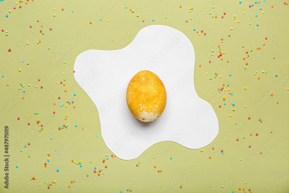Golden egg with sprinkles on color background. Easter celebration