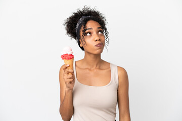 Sticker - Young african american woman with a cornet ice cream isolated on white background and looking up