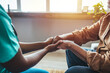 © Dragana Gordic - Photo of Caring nurse or doctor holding an elderly hand with care. Nurse physiotherapist doctor holding hands of a senior or elderly old man patient with love, care, helping, encourage and empathy