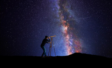 Wall Mural - man looking at the stars through a telescope