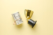A picture of fake money with broken trophy on yellow background. Sports corruption concept.