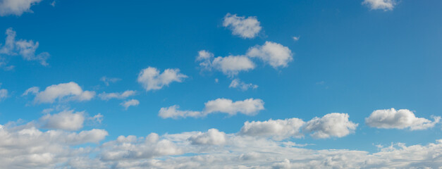 panoramic view over blue deep sky with clouds as a background with copy space.