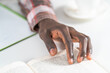 © Svyatoslav Lypynskyy - Close up on young male hand of african american man reading book making notes. Student preparing to the lecture at library reading books and making notes. Adduction concept