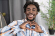 © Svyatoslav Lypynskyy - Charming african man in plaid shirt send love sign gesturing it with hands. African american male model makes love figure by his hands.High quality photo