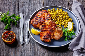 Wall Mural - grilled pork t-bone steaks with boiled green peas