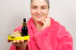A woman keeps natural cosmetics for hair care - a bottle of oils and ubtan, a scrub of herbs