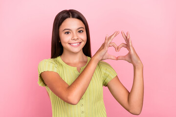 Wall Mural - Photo of romantic affectionate lady fingers show heart symbol wear green top isolated pink color background