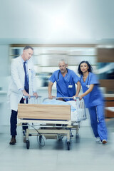 Canvas Print - To the operating room stat. Shot of a group of medical professionals rushing a patient on a gurney down a hospital corridor.