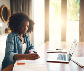 Poster - Sorting out all her plans. Shot of an attractive young woman using a laptop while working from home.
