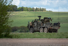 An Army Rapid Assault, Fire Support And Reconnaissance Vehicle In Action On A Military Exercise, Wiltshire UK, Blue And White Cloud Sky