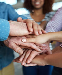 As a team, we can do anything. Closeup shot of co-workers hand put together in an expression of unity and team spirit.