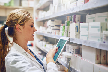 Poster - Doing what it takes to give you the best care. Shot of a pharmacist using her digital tablet while working in a isle.