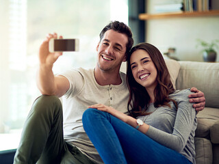 Wall Mural - Happy at home with my love. Shot of a happy young couple taking selfies together at home.