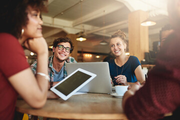 Poster - Enjoying the benefits of a study group. Shot of students studying in a coffee shop.