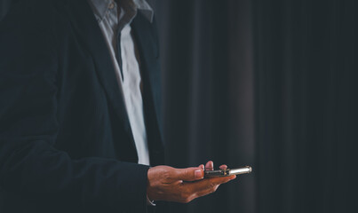 Businessman using smartphone at night time.