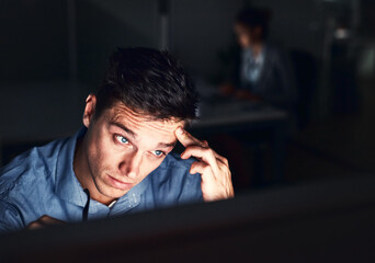 Fototapete - Working the late night grind to get the work done. Cropped shot of a young attractive businessman working late in the office.