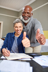 Poster - Our finances are a-okay. Cropped portrait of a senior couple giving you the thumbs up while working on their finances at home.