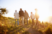 Strolling On A Golden Afternoon. Rearview Shot Of A Multi-generational Family Walking Together At Sunset.