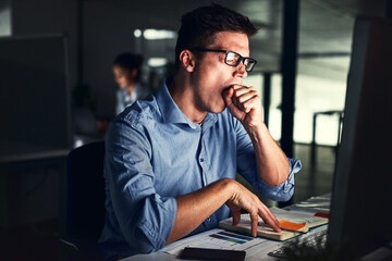 Fototapete - The late shift can get exhausting. Cropped shot of a young attractive businessman working late in the office.