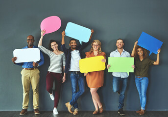 Poster - Let us help you get your word out. Studio shot of a diverse group of people holding up speech bubbles against a gray background.