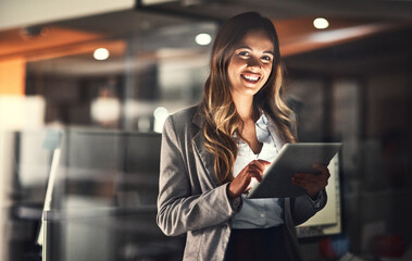 Poster - She thrives with hard work. Cropped shot of a young attractive businesswoman using a tablet while working late at night in the office.