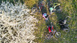 © Iuliia Sokolovska - Spring family cycling on bikes aerial top view from above, happy active parents with children have fun and relax on grass under spring blossoming tree, family sport and fitness on weekend