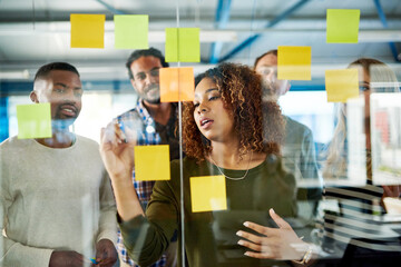Poster - Another idea Lets write it down. Shot of colleagues having a brainstorming session with sticky notes at work.