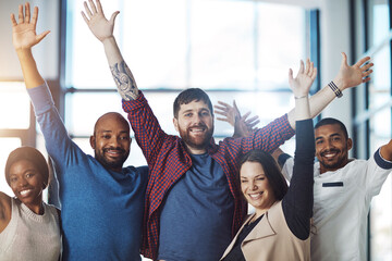 Poster - Winning is what we do. Portrait of a group of young colleagues cheering at work.