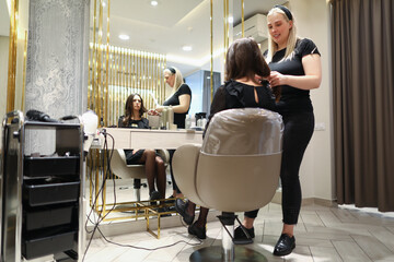 Woman sitting in barber chair in front of the mirror