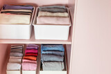 Fototapeta  - Closeup shelves pink female childish closet with neatly folded clothes Marie Kondo vertical storage