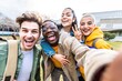 © Davide Angelini - Multiracial students company taking selfie portrait in university campus - Multi ethnic best friends laughing at camera outside - Teens having fun together - Youth culture and school concept