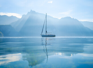 Wall Mural - a yacht against the backdrop of the mountains in switzerland. calm water and bright sunny day. a pop