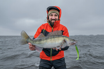 Wall Mural - Success zander fishing. Happy fisherman with big walleye fish trophy at lake