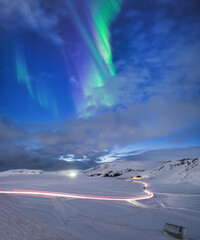 Wall Mural - aurora borealis in iceland. northern lights over the road. a winter night landscape with bright ligh