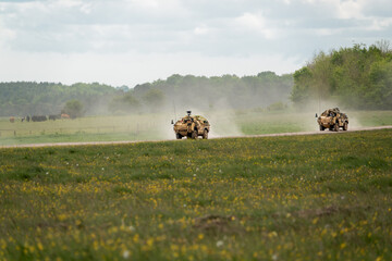 two Supacat Jackal army rapid assault, fire support and reconnaissance vehicles in action on a military exercise, Wiltshire UK