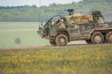 British army Supacat Jackal 6x6 rapid assault, fire support and reconnaissance vehicles on a military battle training exercise, Wiltshire UKre UK