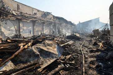 Burnt warehouse in fire. Ruined and damaged building. Burned object in industrial zone. 