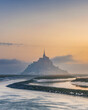 Moody sunrise at Le Mont Saint Michel abbey on the island in foggy morning, Normandy, Northern France, Europe