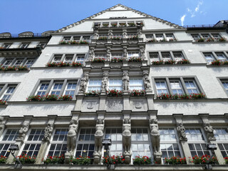 Sticker - A low angle shot of a white building facade with flowers on balconies