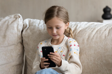 digital addicted kid engaged in smartphone using, watching media on mobile phone at home, reading, c