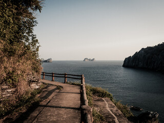 Wall Mural - bay at sunset, pedestrian road with sea view.