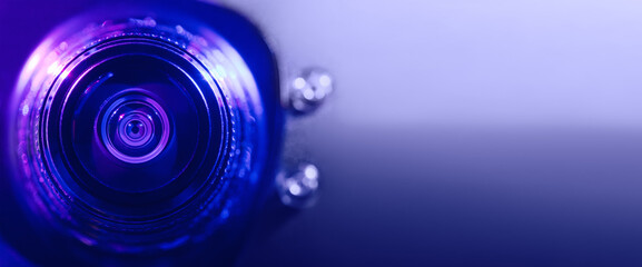 Wall Mural - .Camera lens with purple and blue backlight. Banner